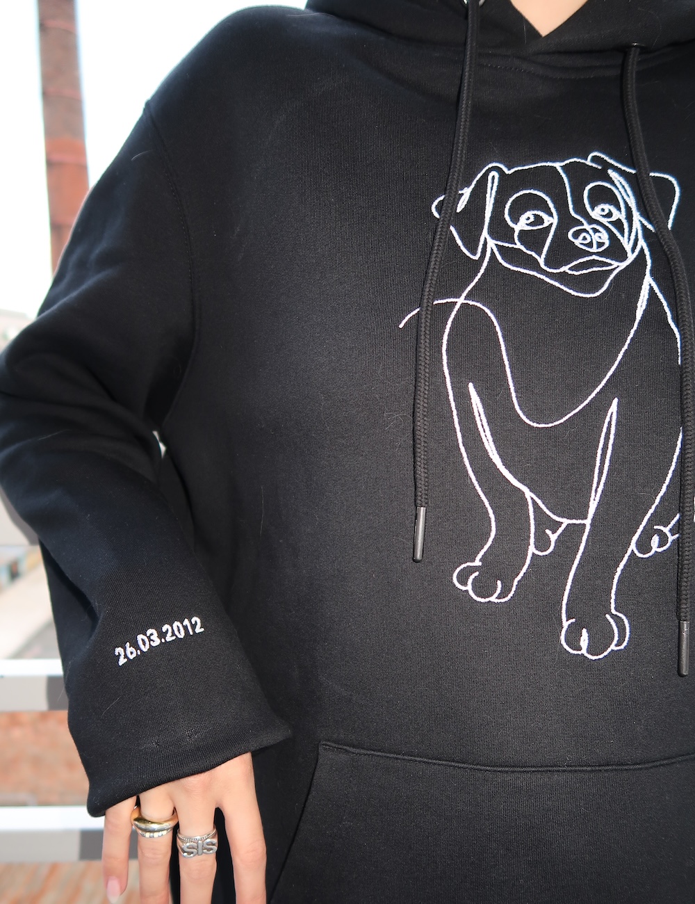Hoodie noir personnalisé avec un chien brodé sur la manche